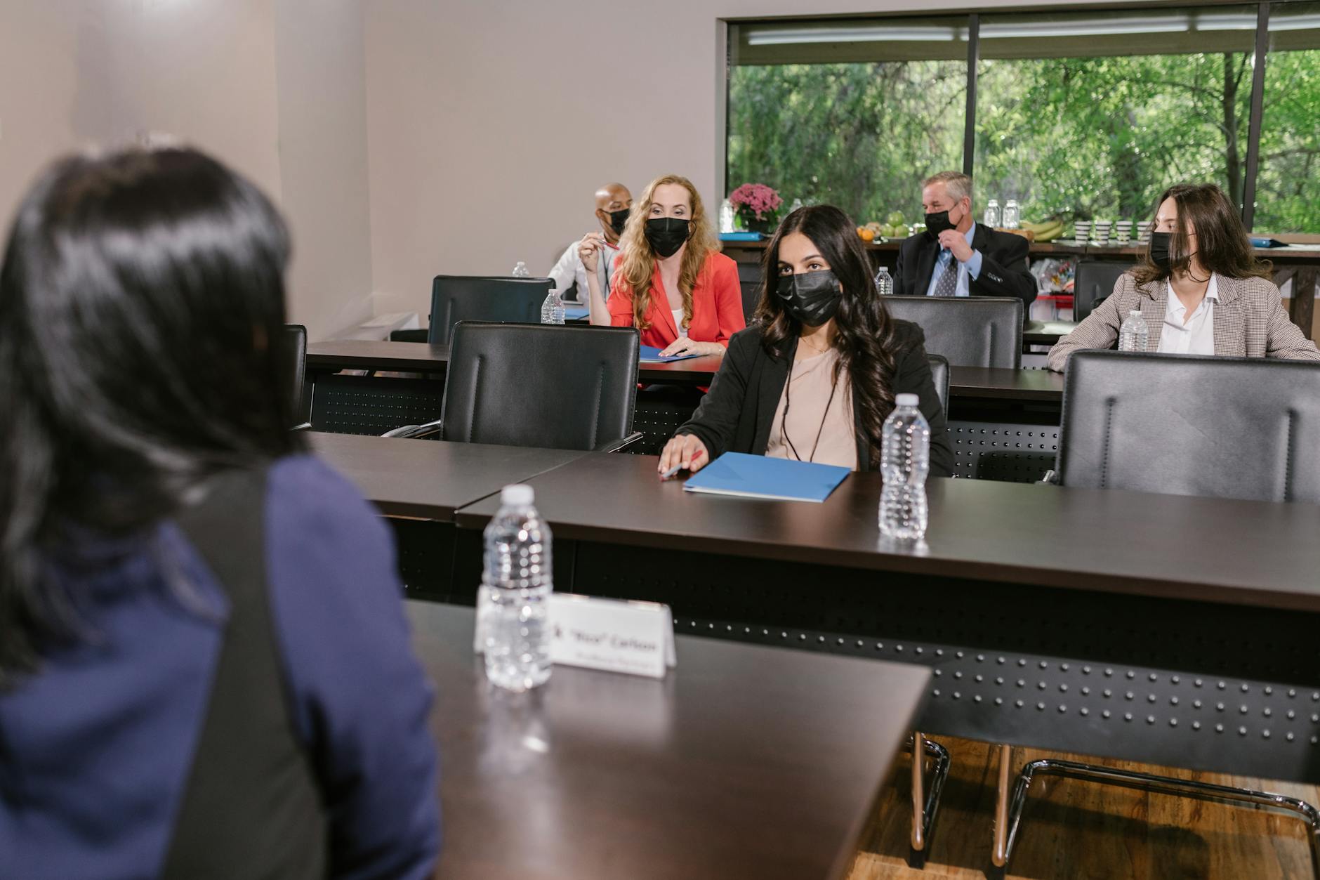 Business professionals with face masks attending a meeting in a conference room.