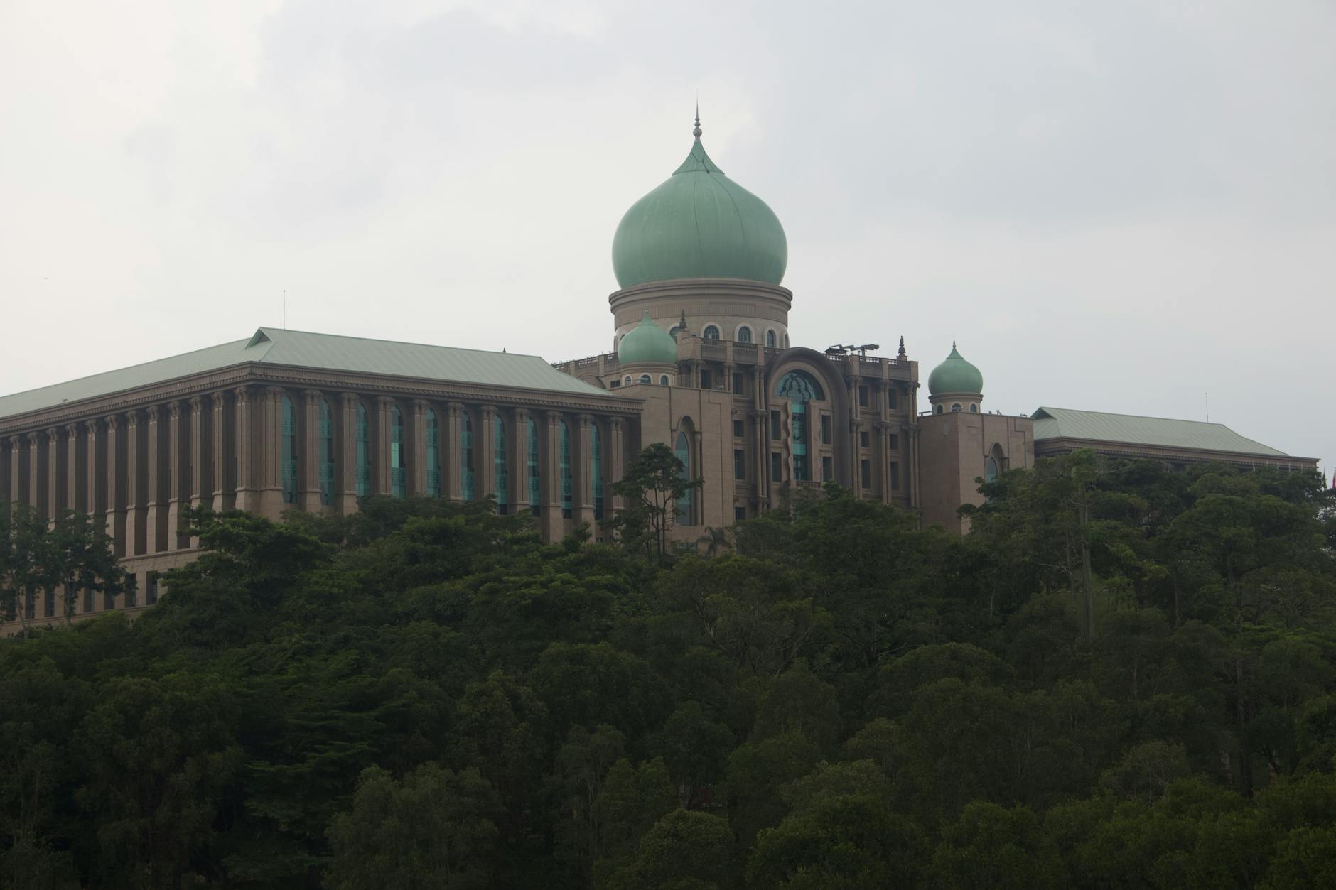 Scenic view of Malaysia's Prime Minister's Office in Putrajaya surrounded by lush greenery.