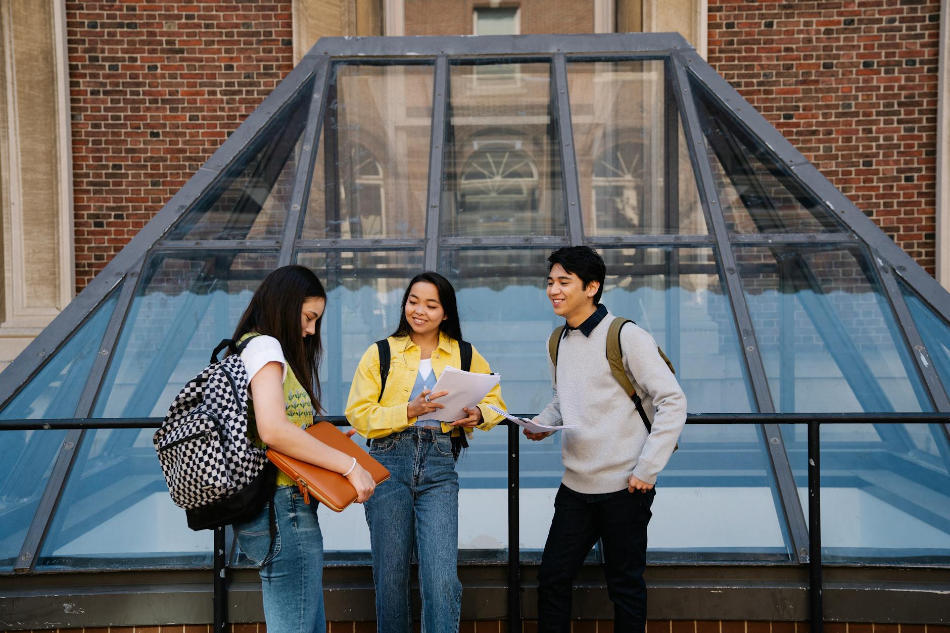 Students talking and studying together at a university campus outdoors.