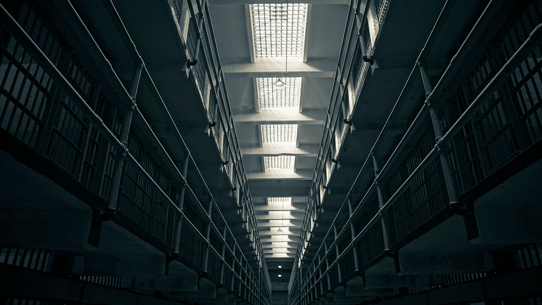A low-angle view of Alcatraz prison cell block, showcasing steel railings.